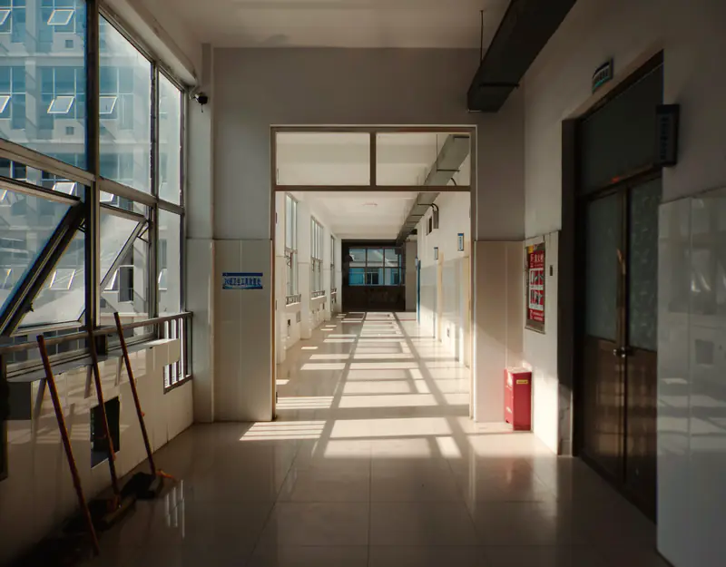 A long hospital hallway with sunlight falling across the floor