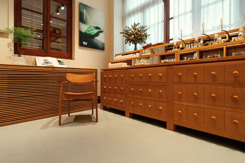 A shop interior with rows of wooden drawers and a chair beside the counter